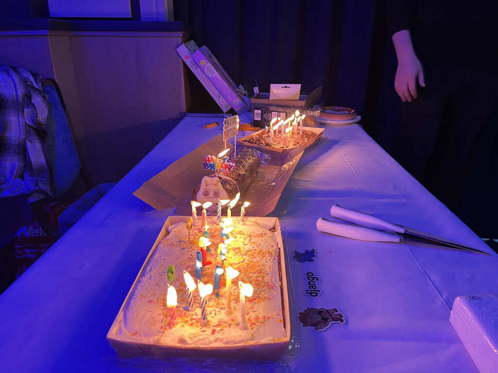Close-up of three birthday cakes covered in lit candles